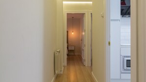 A narrow hallway with wooden flooring, white walls, and a ceiling light. - Spacious & Renovated 2BR Apt with Parking, Near Calle Laurel, Logroño (Logroño)