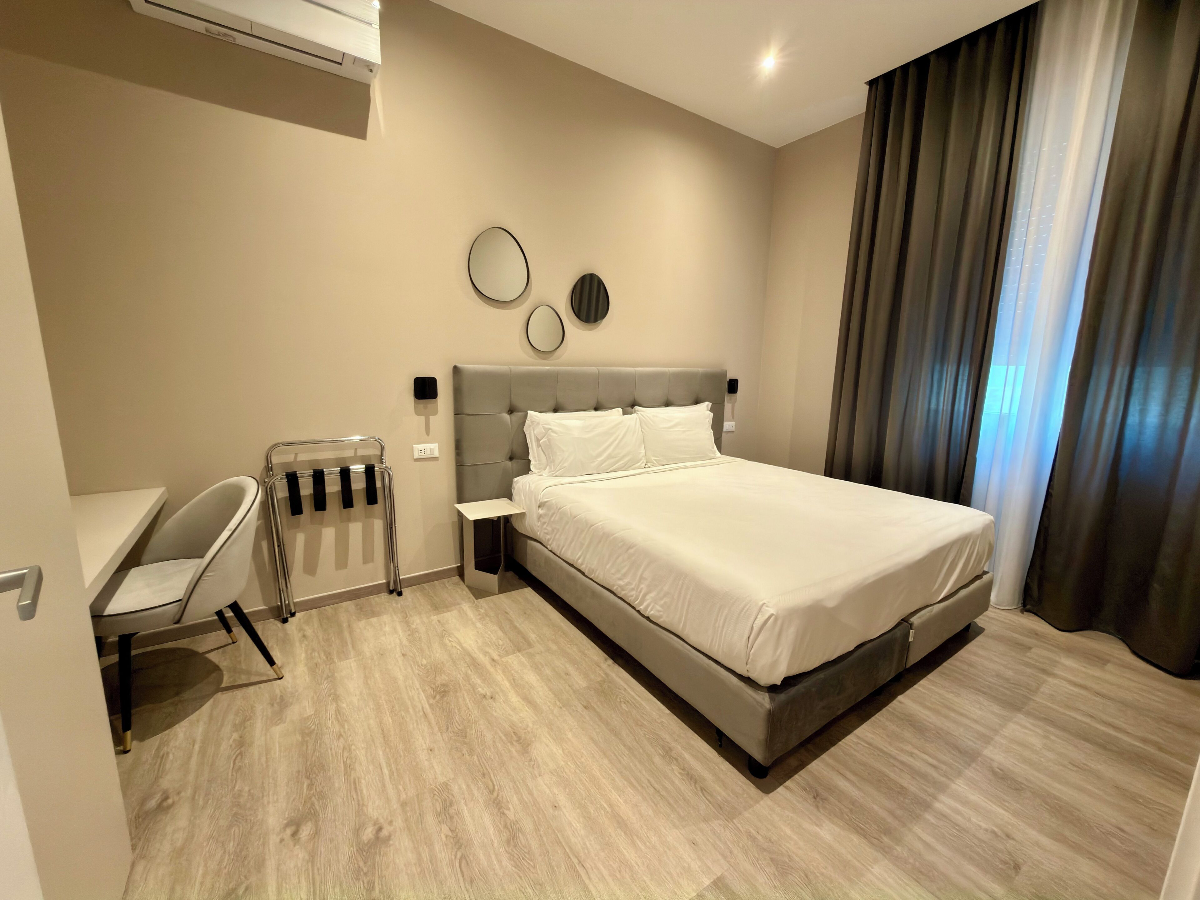 Ein modernes Hotelzimmer mit einem großen Bett, einem Schreibtisch und einem Stuhl.