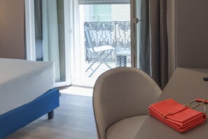 Una habitación de hotel con cama, una silla y una mesa.