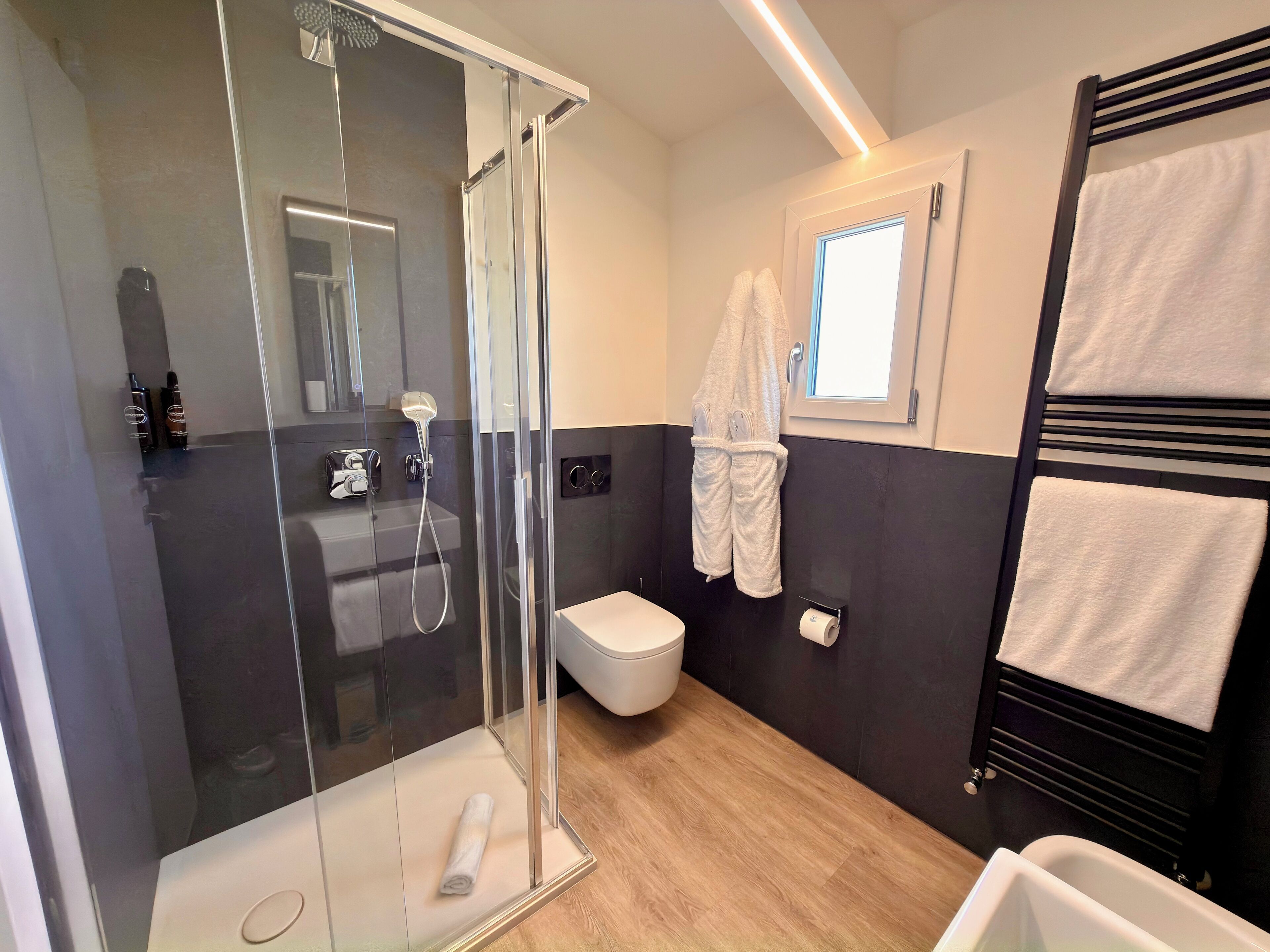 Een moderne badkamer met een douchecabine, een toilet en een bad.