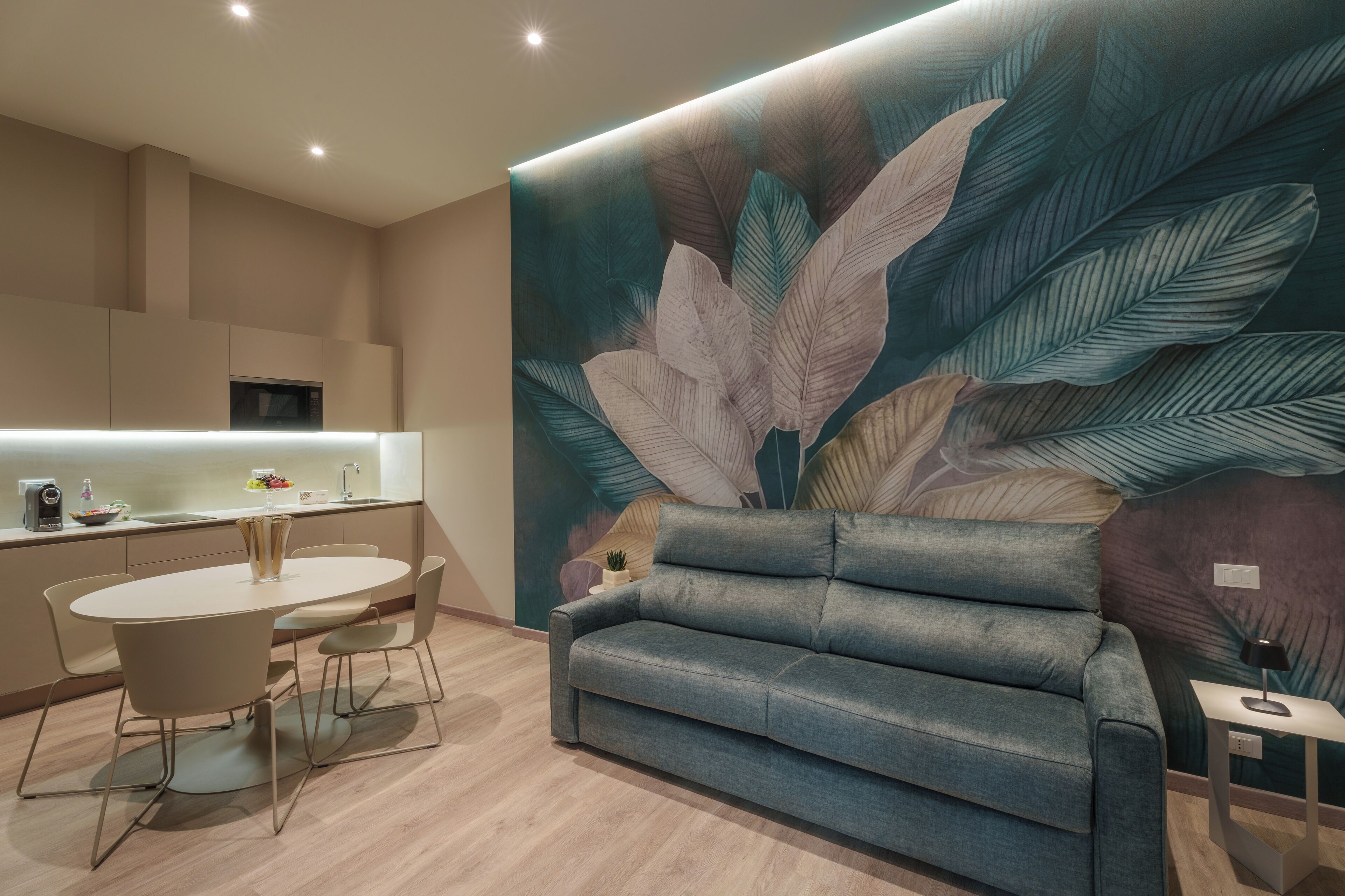 A modern living room with a large wall mural, a sofa, and a dining area with a table and chairs.