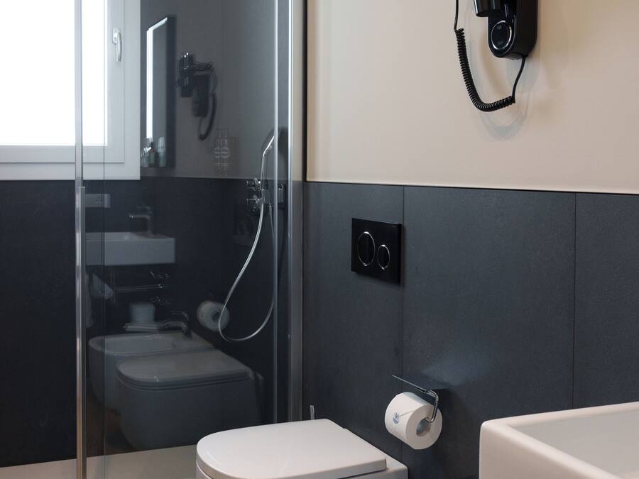 Une salle de bain moderne avec une douche à parois de verre, des toilettes, un bidet et un porte-serviettes.