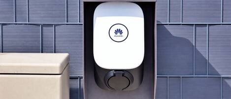 A Huawei charging station mounted on a wall with a tiled background.