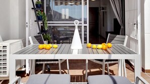An outdoor patio with a table and chairs, a white umbrella, and a potted plant. - Quiet apartment between golf and sea with pool (Rincón de la Victoria)