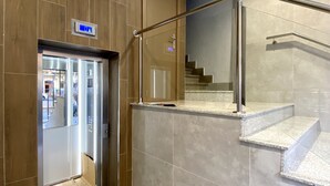 A modern elevator with a sign indicating the direction to the lift. - Central Apartment in Logroño: 5-Min Walk to Calle Laurel & Gran Vía, Next to City Hall (Logroño)