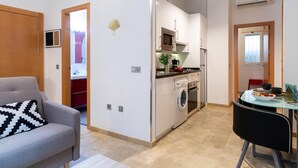 A compact living space with a kitchenette, a dining area, and a sofa. - Historic Málaga Apt: Quiet Retreat w/ Courtyard, 4-min Walk to Larios (Málaga)