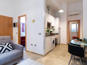 A compact living space with a kitchenette, a dining area, and a sofa. - Historic Málaga Apt: Quiet Retreat w/ Courtyard, 4-min Walk to Larios (Málaga)