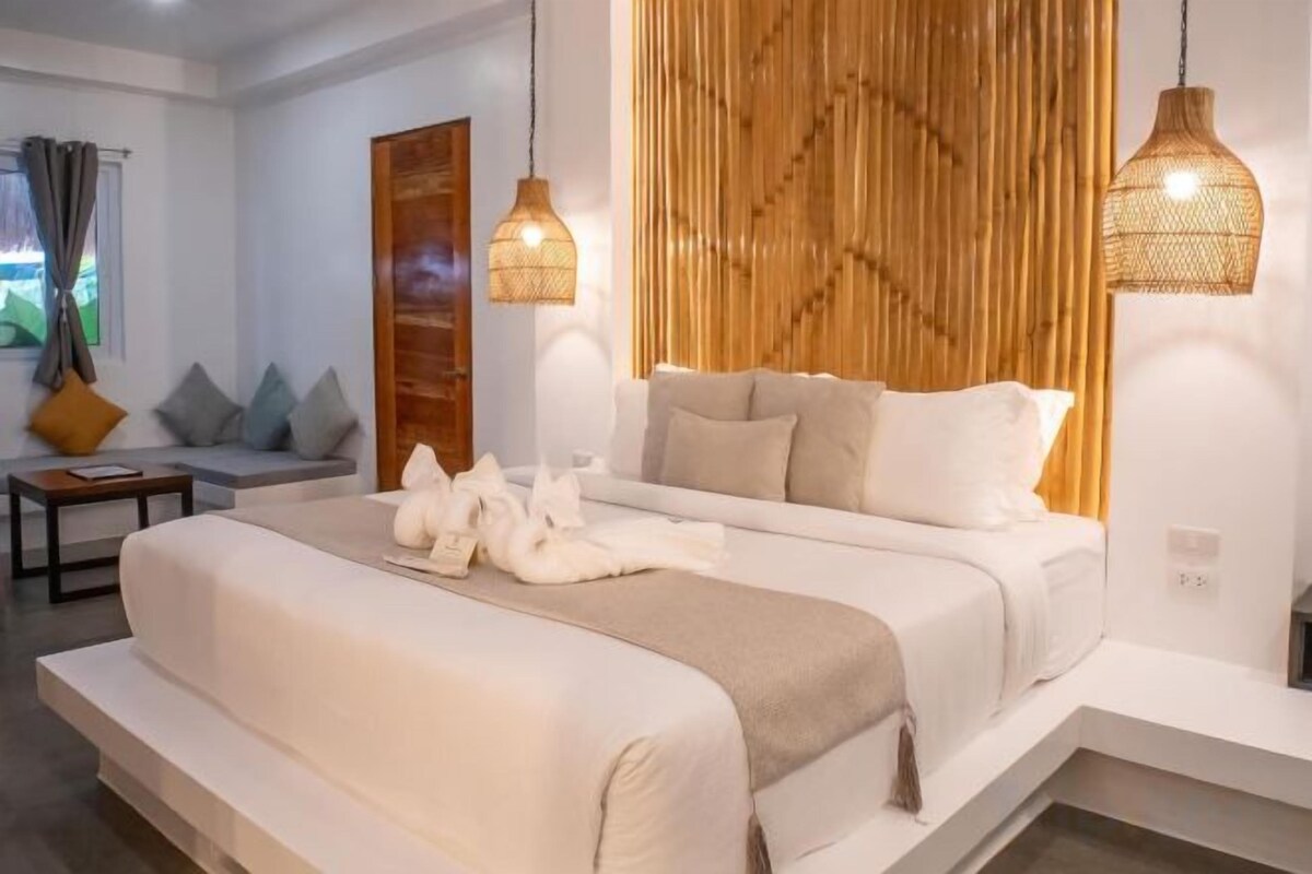 Une chambre à coucher moderne avec un grand lit, des lampes de chevet et un mur d’accent en bois.