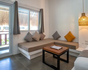 A modern living room with a sectional sofa, a wooden coffee table, and a hanging light fixture. - Bathala Resort (Panglao)