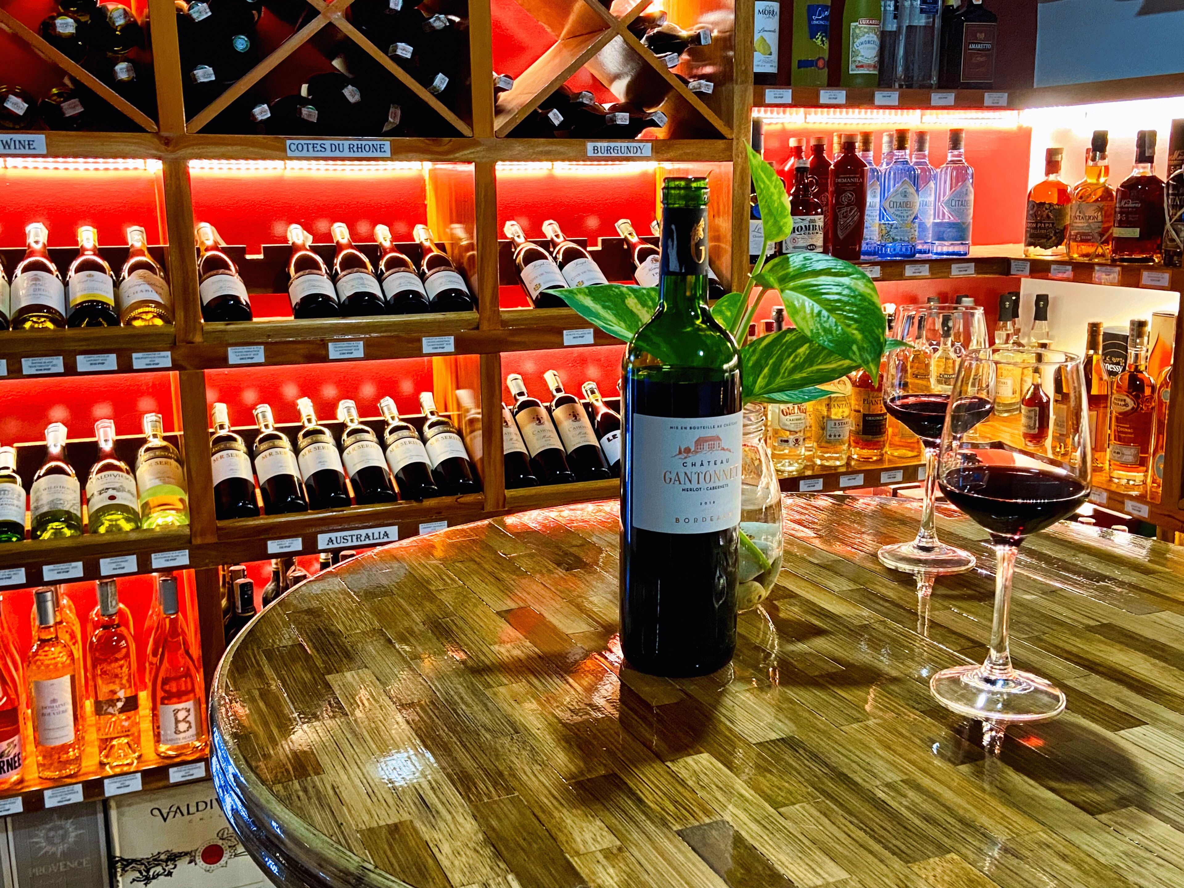 A bar with a variety of wine bottles and glasses.