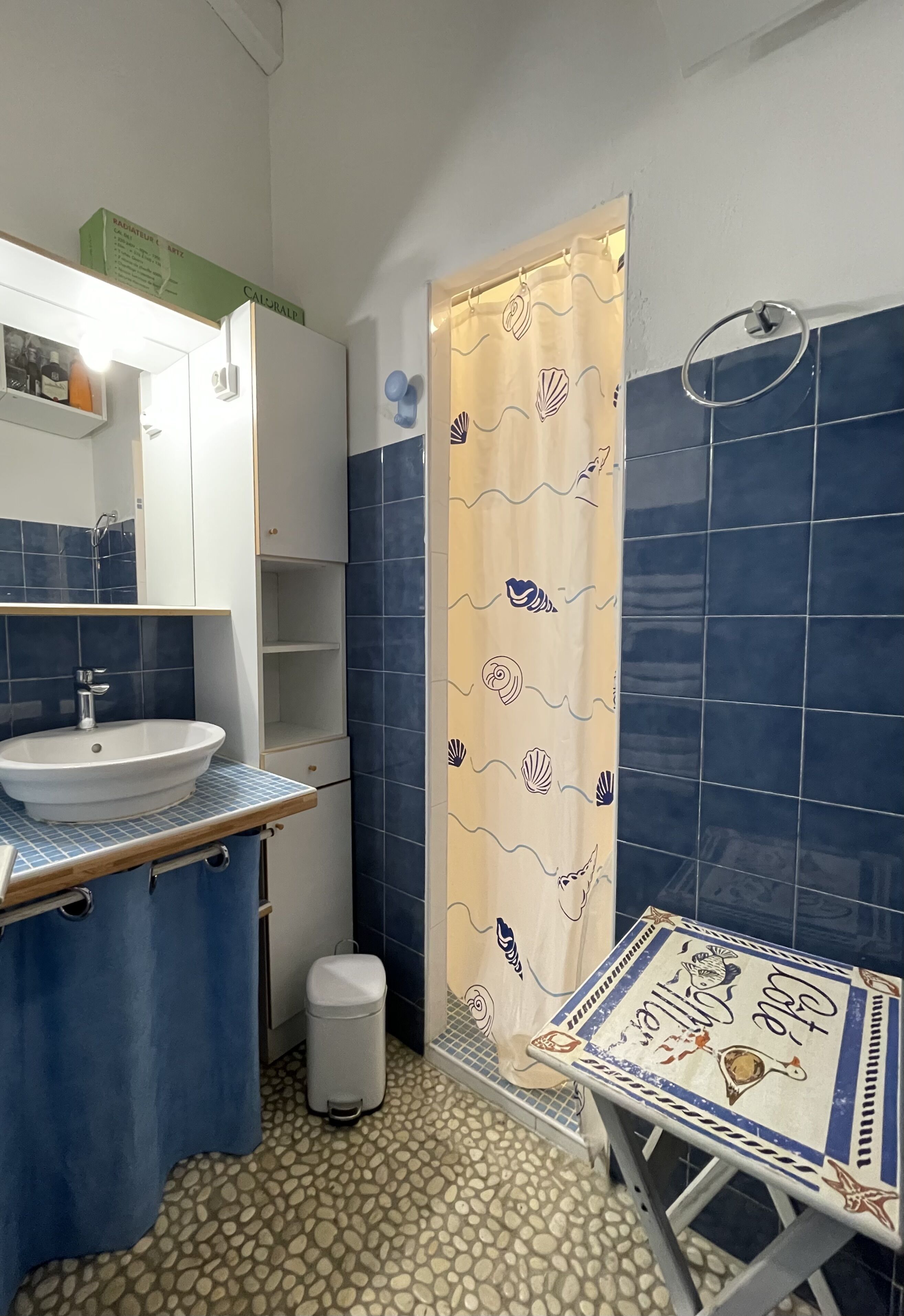 A bathroom with a sink, mirror, and tiled walls.