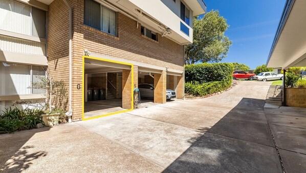 A residential building with a garage entrance, numbered 5 and 6, and a visible staircase leading to the upper floor.
