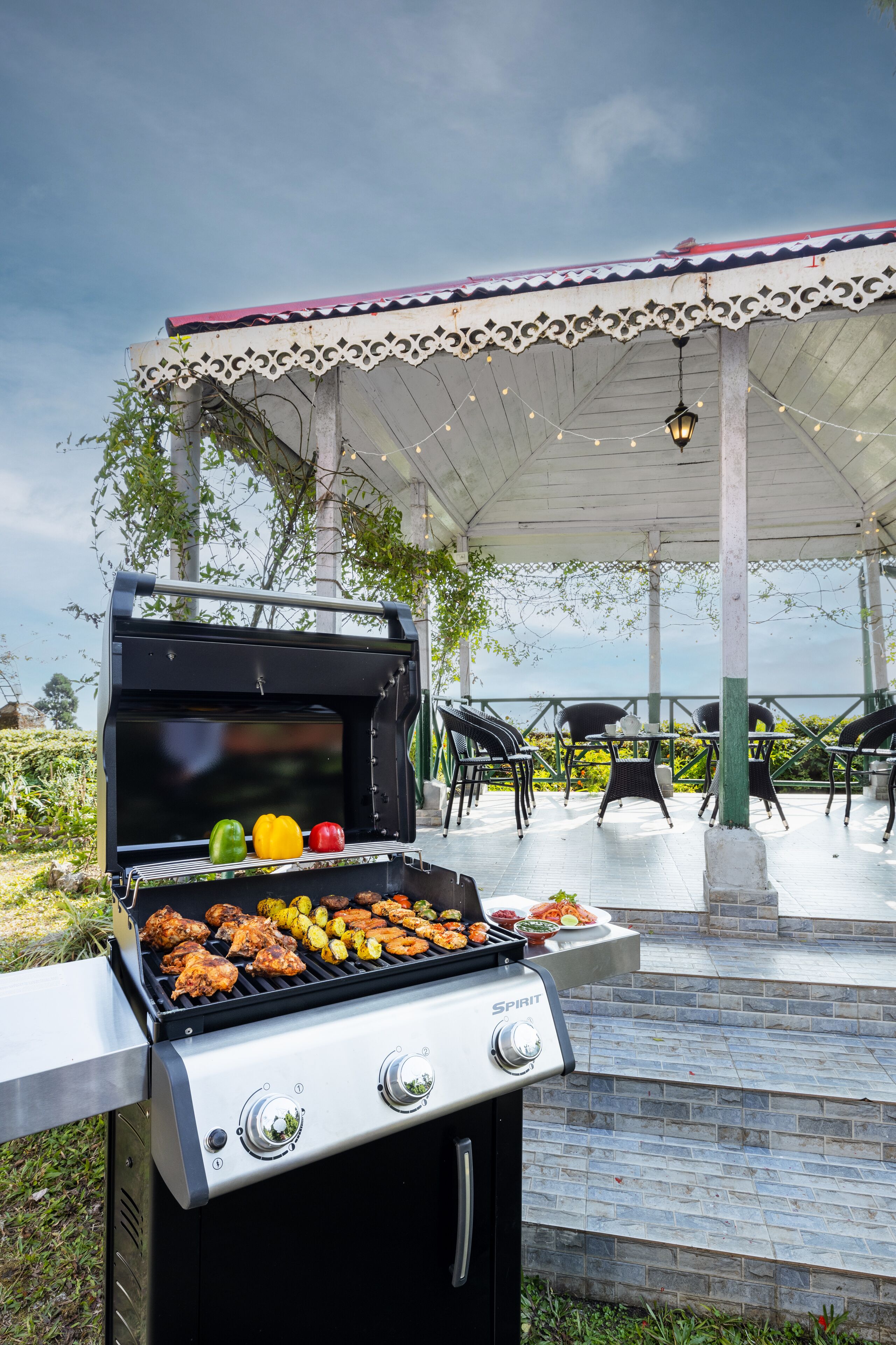Une terrasse extérieure avec un barbecue, des chaises et un espace abrité.