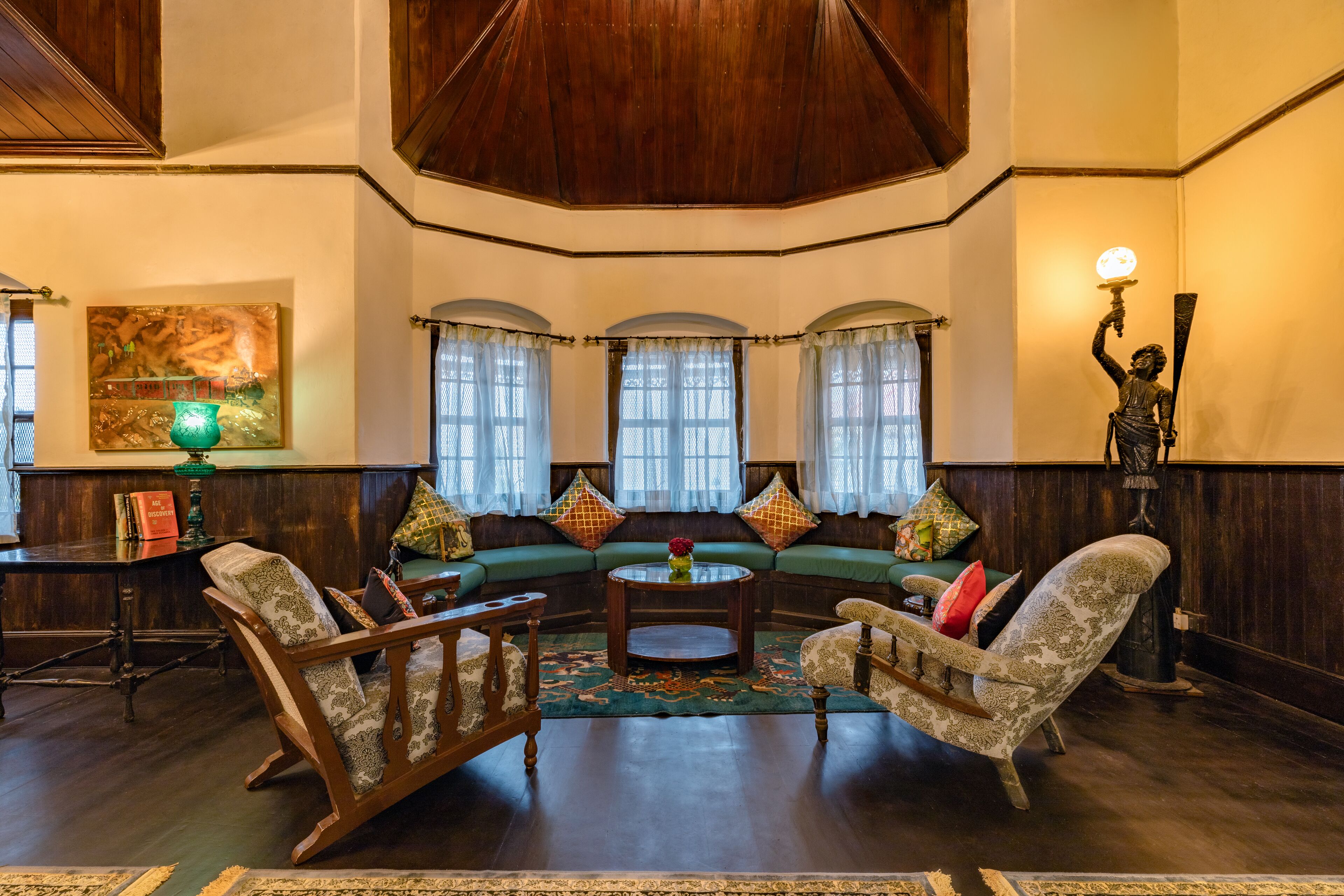 A spacious living room with a large sofa set, a coffee table, and a statue.
