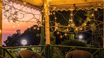 Relax under the stars in a serene garden setting, surrounded by lush greenery and comfortable seating.