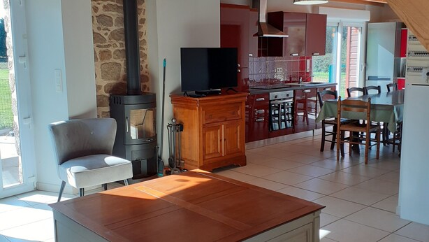 A spacious living area with a wooden ceiling, a stone fireplace, a television, and a dining area with chairs and a table. - Beautiful Gite for 14 people, Saint Malo/Cancale/Le Mont Saint Michel : Le Chêne (Baguer-Pican)