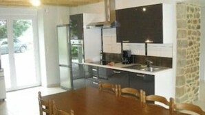 A modern kitchen with a large island, built-in appliances, and a dining area with wooden chairs. - Beautiful Gite for 14 people, Saint Malo/Cancale/Le Mont Saint Michel : Le Chêne (Baguer-Pican)