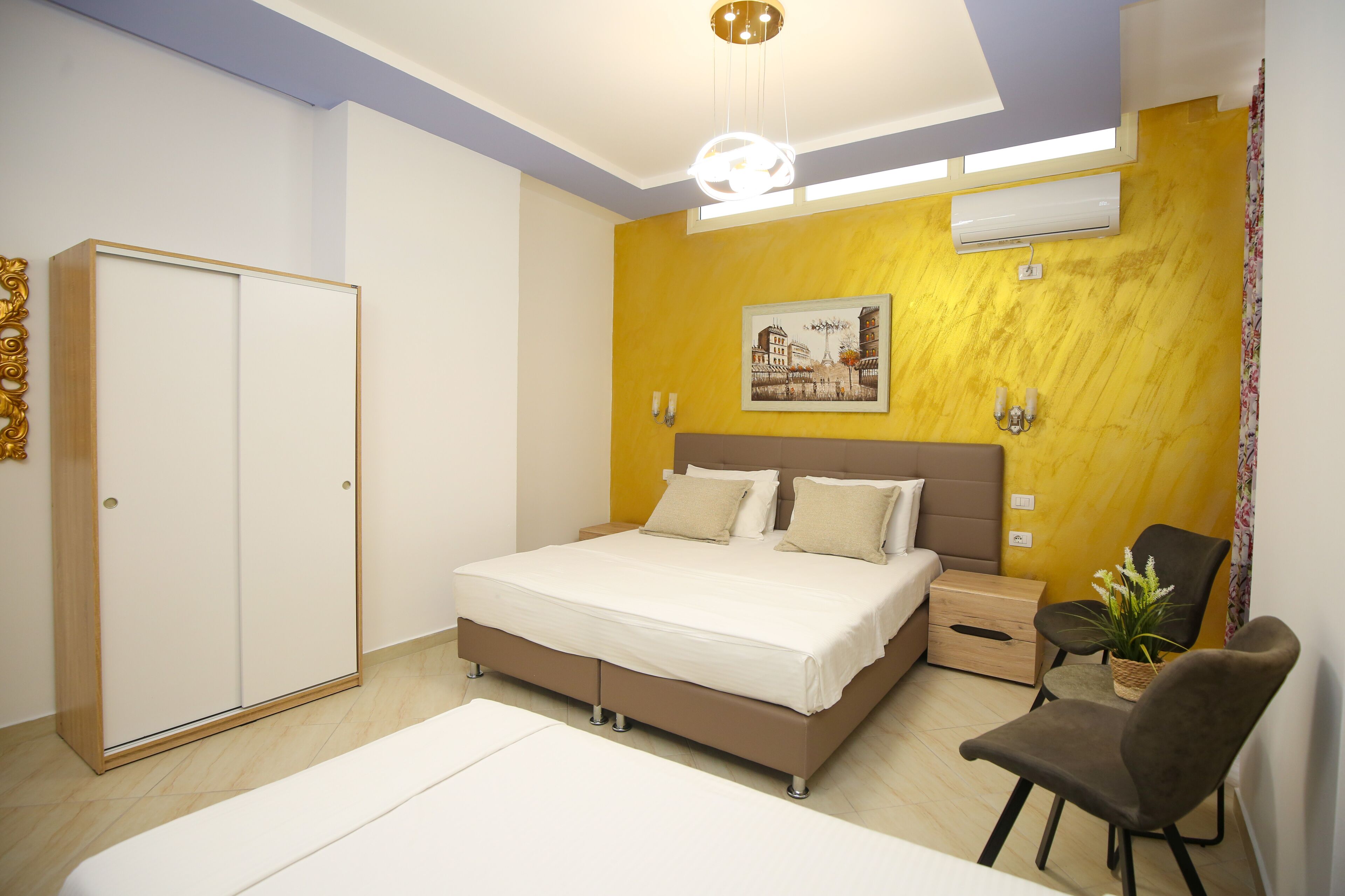 A bedroom with a bed, bedside table, chair, and wardrobe.