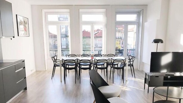 A modern living room with a dining area, large windows, and a flat-screen TV. - Downtown Fantail (Porto)