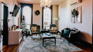 A cozy living room with a chandelier, a Christmas tree, and a fireplace. - Spacious and Elegant Condo in Downtown Hillsboro (Hillsboro)