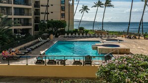 A hotel pool area with multiple lounge chairs and a large pool.