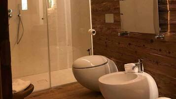 Une salle de bain avec un mur en bois, une douche, des toilettes et un lavabo.