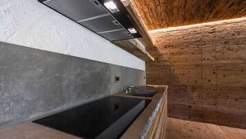 A modern kitchen with a built-in sink and a wooden ceiling.