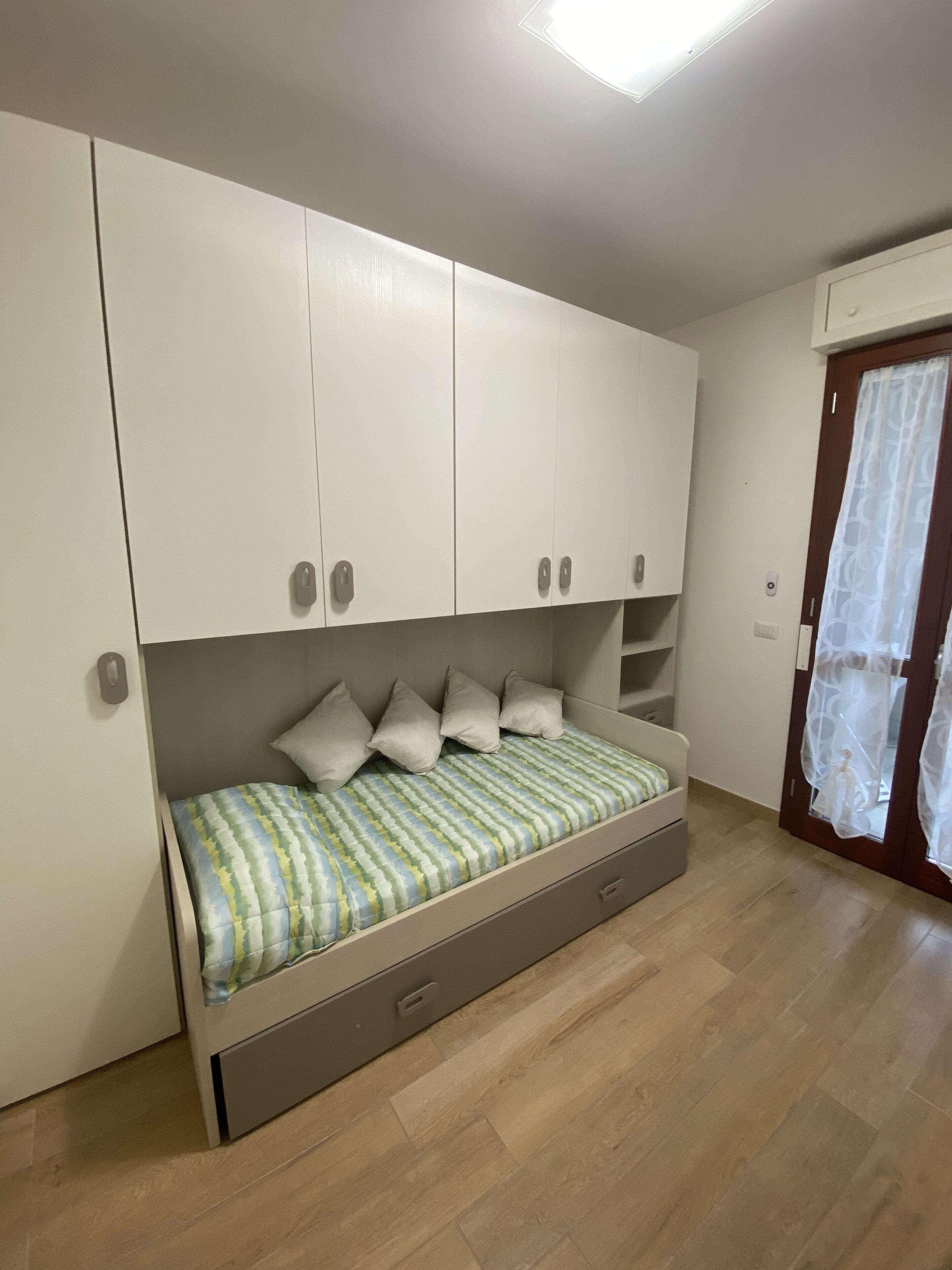 Ein Schlafzimmer mit einem Bett, eingebauten Schränken und Holzboden.