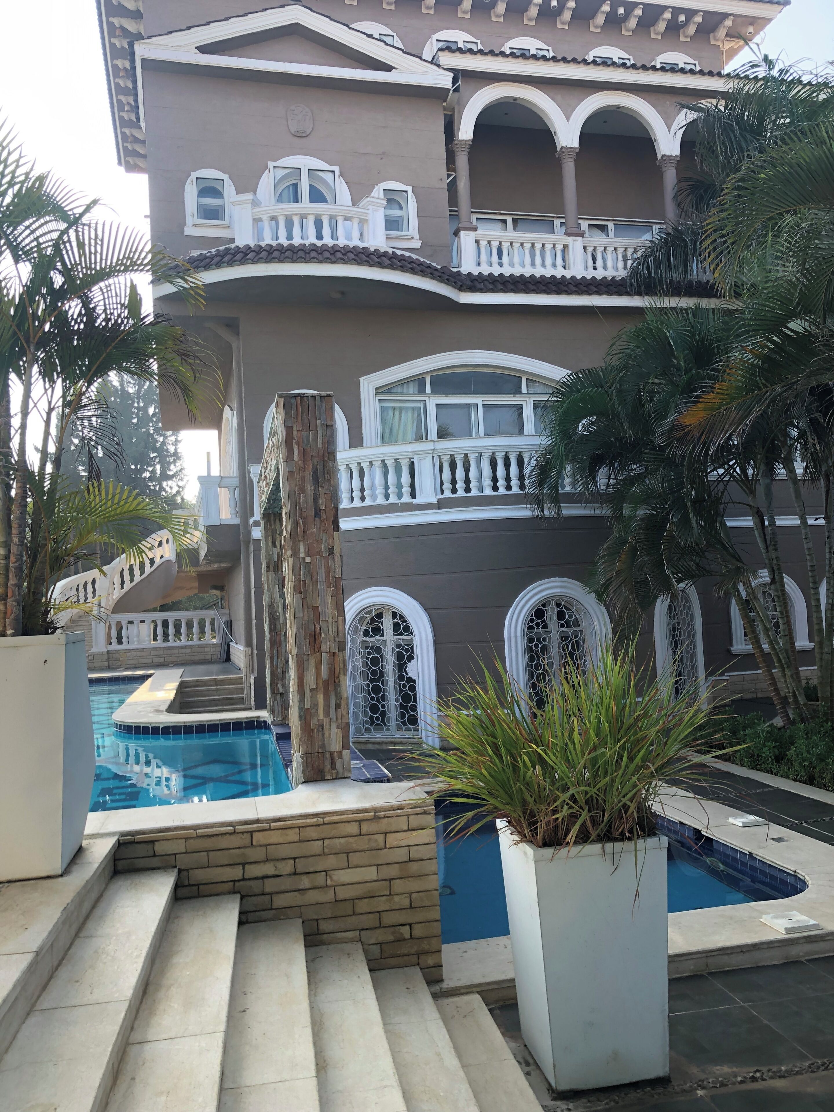 A multi-story building with a pool, steps leading to the pool, and a staircase.