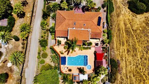 An aerial view of a property with a swimming pool, solar panels, and a red-roofed building. - Bungalow with apartment in a quiet location and large pool (Burgau)