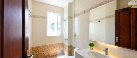 Un baño con inodoro, lavabo y ducha.
