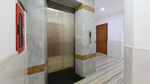 Un ascensore con pareti in marmo e una porta in legno.