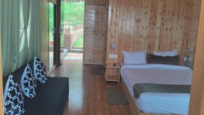A wooden cabin-style room with a bed, a sofa, and a view of the outdoors. - LaSerene The Cottage (Nainital)