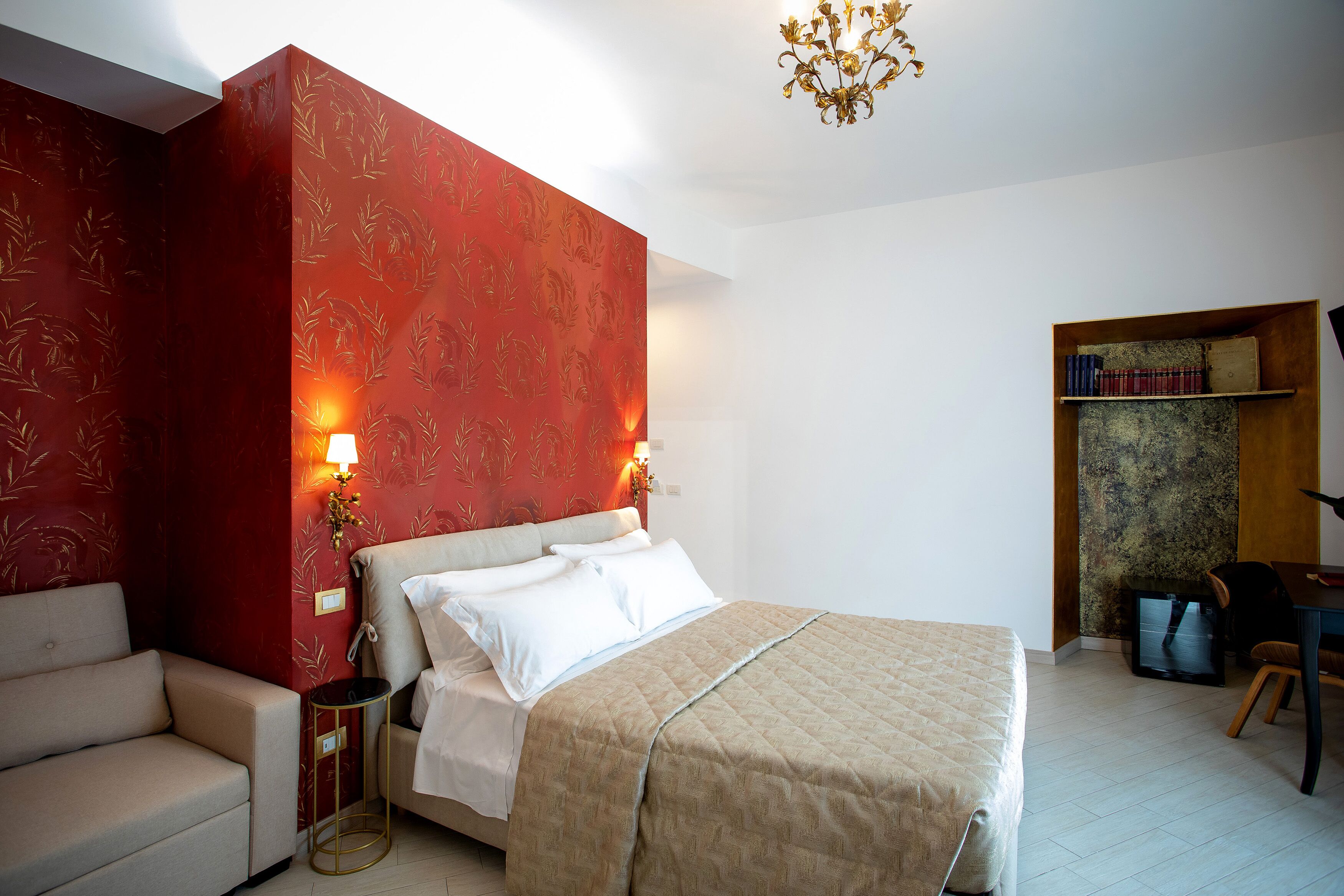 Un dormitorio con una cama, un sofá, una mesita, un televisor y una estantería.