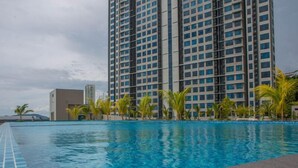 A swimming pool with a view of tall buildings in the background. - Jesselton Point Homestay  (Kota Kinabalu)
