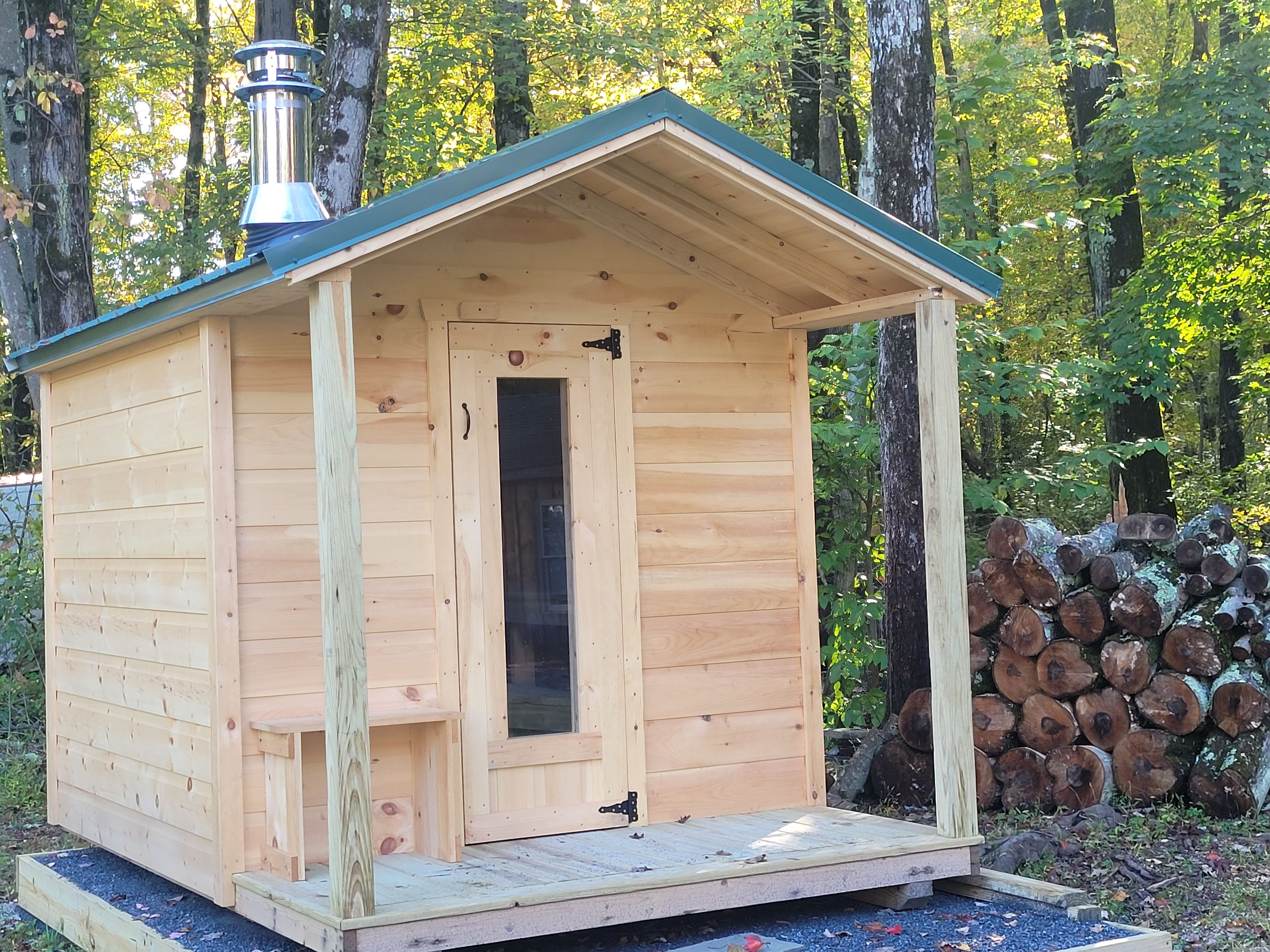 Une cabane en bois avec un toit à deux versants, une porte et une cheminée.