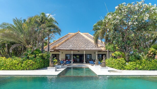 Ein Resort mit Pool, Liegestühlen und tropischer Bepflanzung.