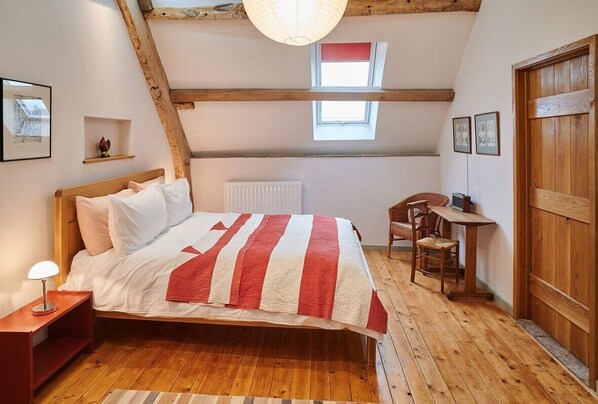 Un dormitorio acogedor con una cama de madera, un escritorio y una silla.