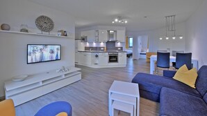 Un appartamento moderno con zona soggiorno, sala da pranzo e cucina.