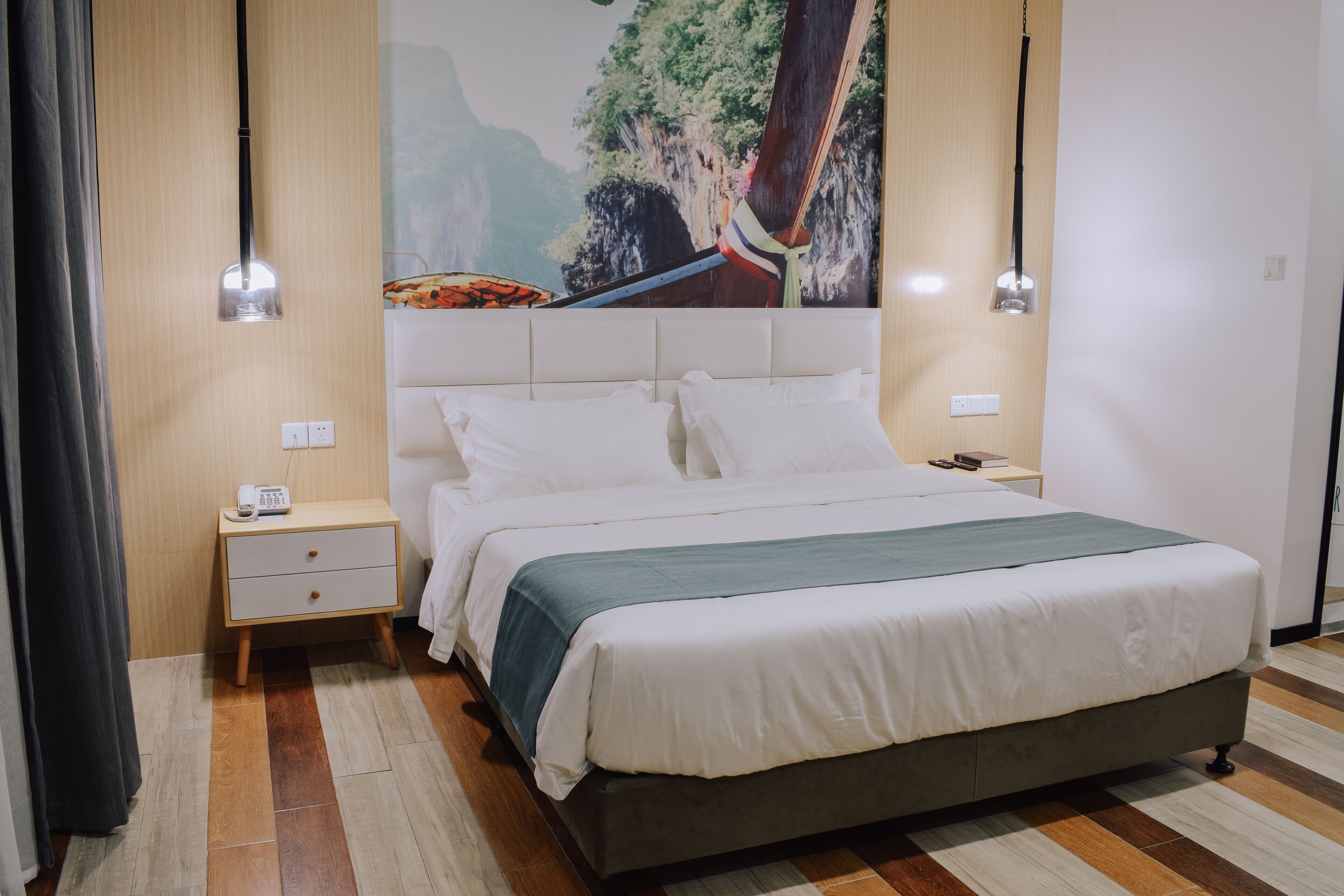 Un dormitorio ordenado con cama, mesitas de noche y una lámpara de pared.