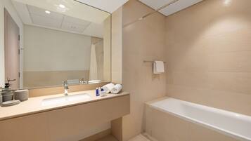 Un bagno moderno con uno specchio grande, un lavandino e una vasca da bagno.