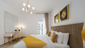 Een moderne hotelkamer met een groot bed, een bureau en een spiegel.