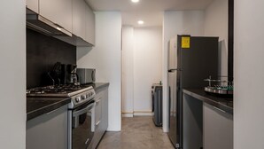 Una cocina compacta equipada con estufa, horno, microondas y refrigerador.