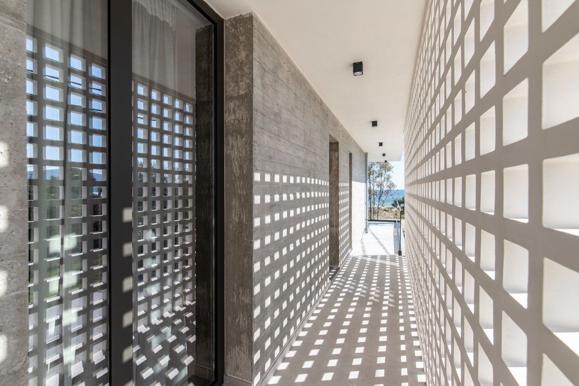 Um corredor com piso e paredes estampados, que leva a uma área externa iluminada.
