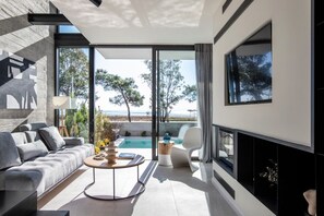 Una sala moderna con un sofá, una mesa de centro y vista a la playa.