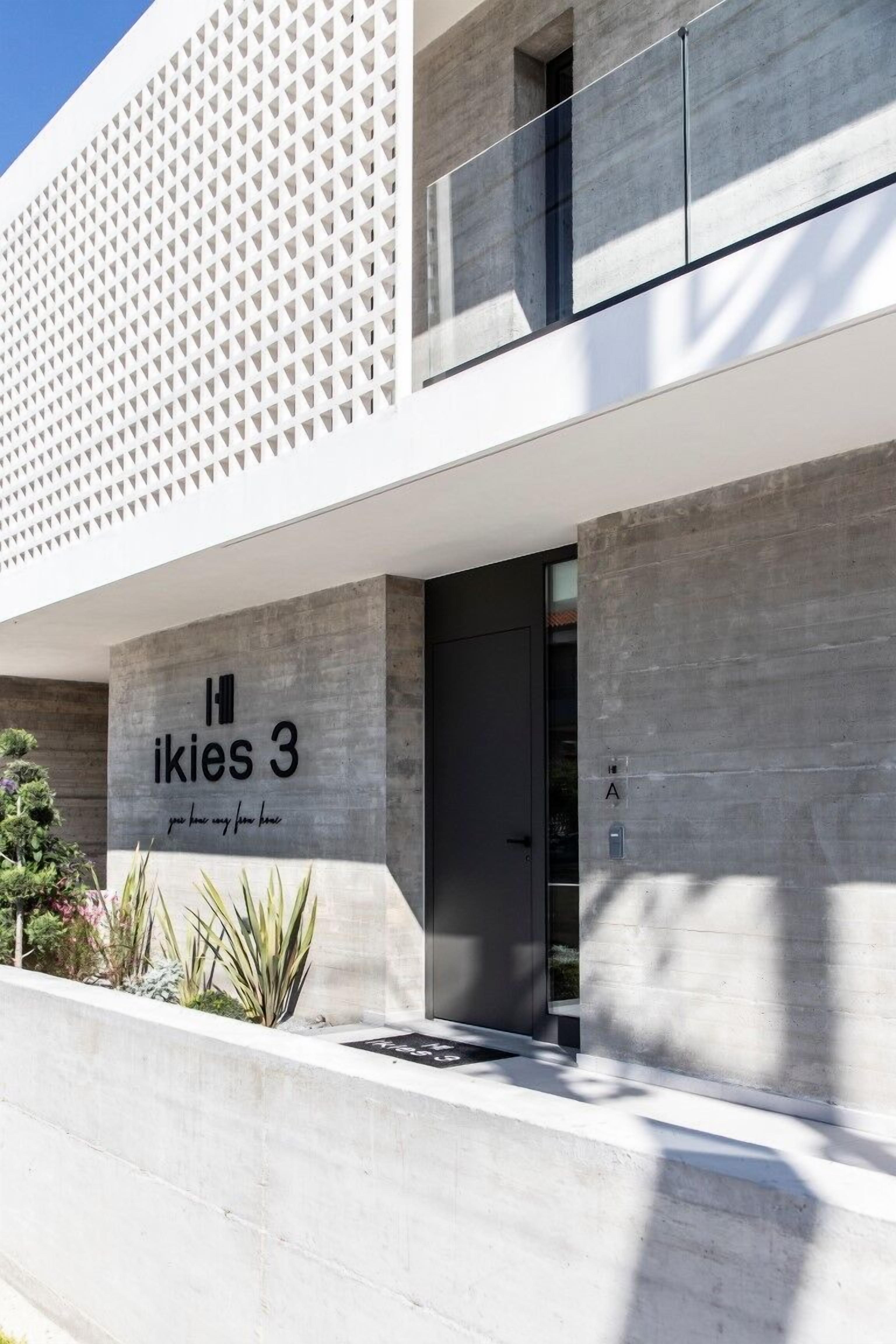 Ein modernes Gebäude mit einem Schild, auf dem "Ikies 3" steht, und einer Betonfassade.