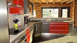 A modern kitchen with a wooden ceiling, a large window, and a view of a mountain. - Chalet montagne neuf 4* avec WI FI et jacuzzi 10 personnes plus 2 pers sup (Rencurel)
