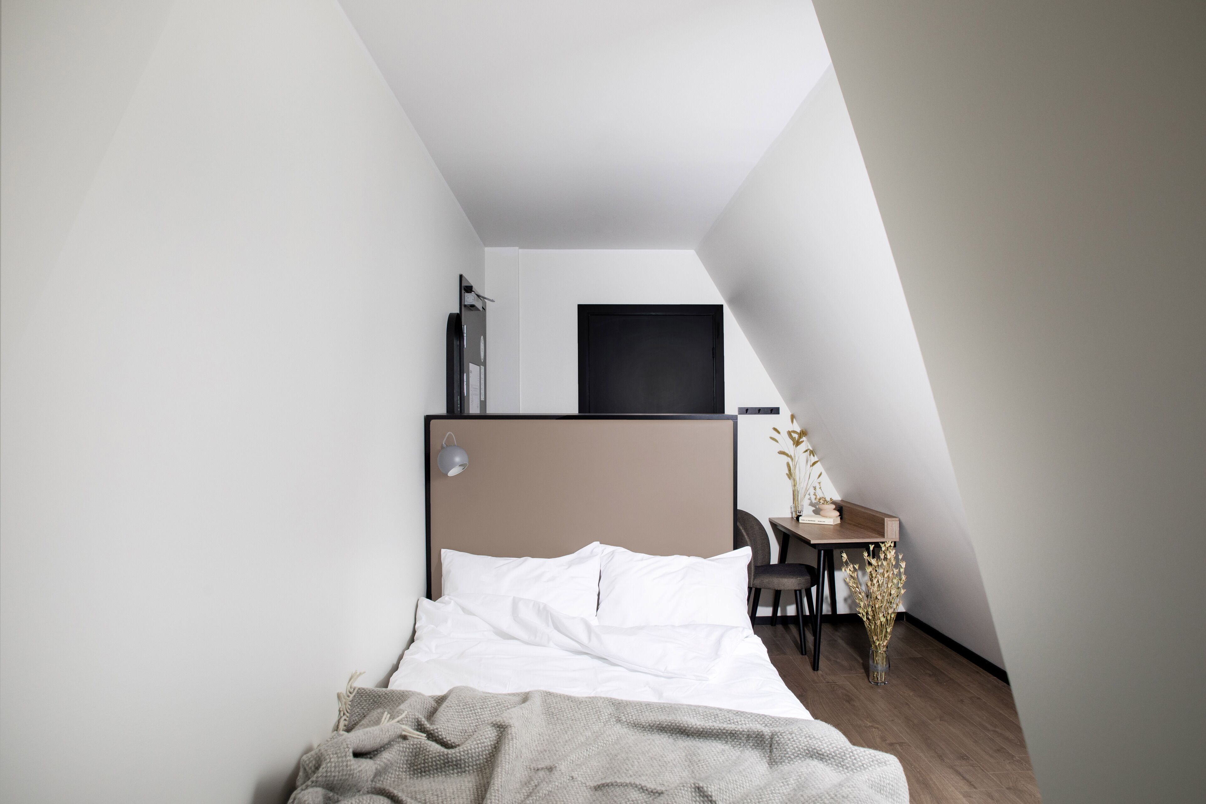 Un dormitorio con una cama, un escritorio y una silla.