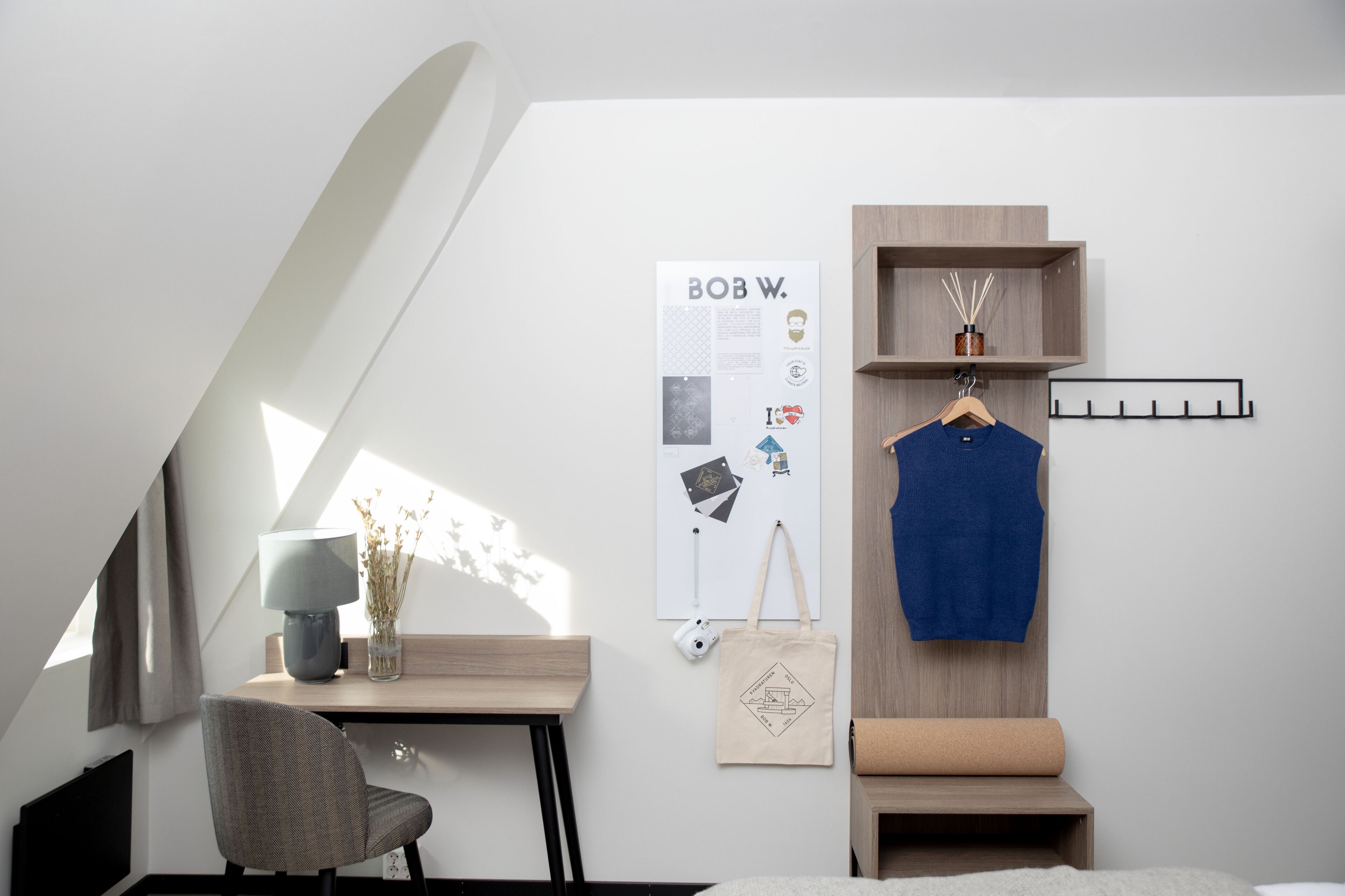 A modern room with a desk, chair, and a hanging blue garment.
