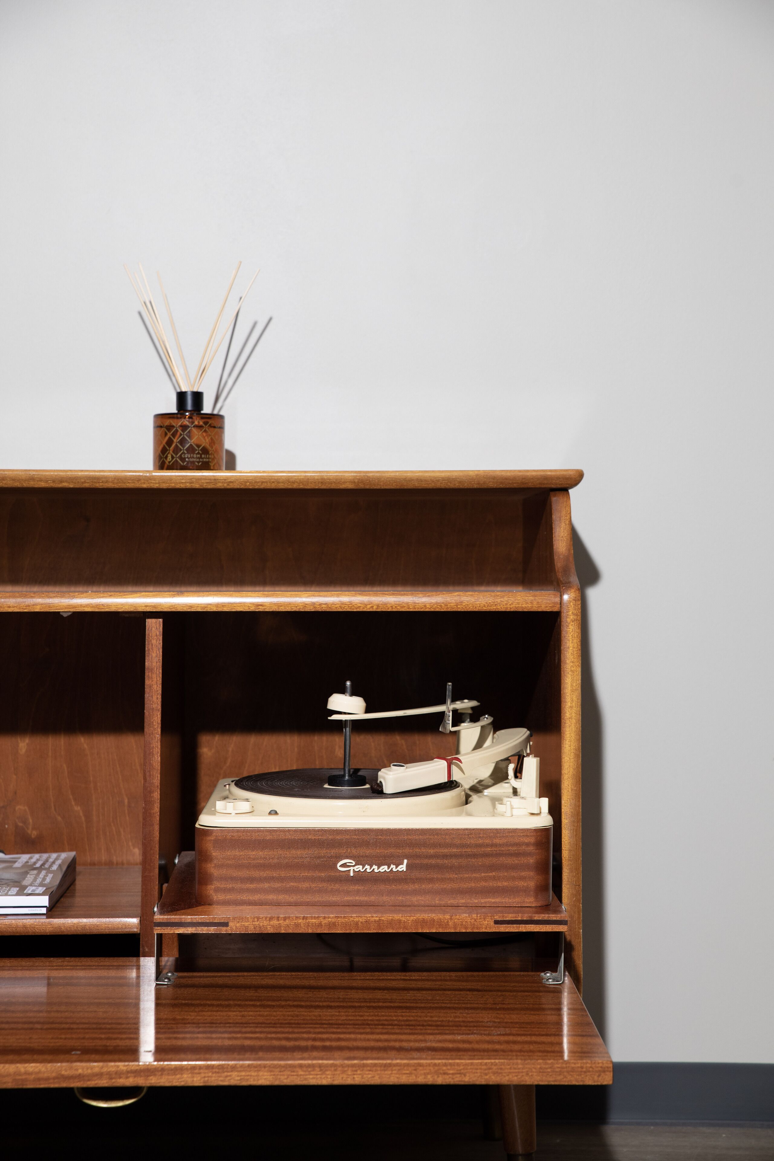 A wooden music player with a shelf above it.